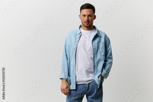 Serious young tanned handsome man in casual basic t-shirt look at camera posing isolated on over white studio background. Copy space Banner Mockup. Lifestyle People emotions concept