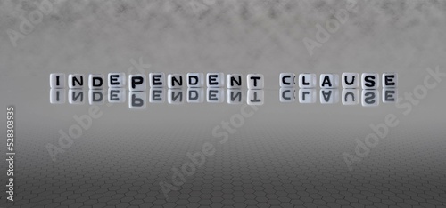 independent clause word or concept represented by black and white letter cubes on a grey horizon background stretching to infinity