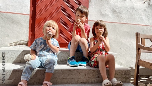 Wallpaper Mural Three siblings sitting and eating ice cream on the stairs Torontodigital.ca
