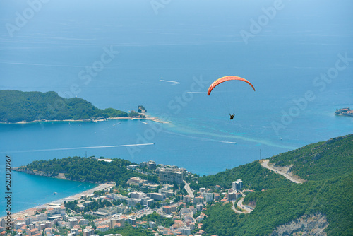 Paragliding tandem with tourist above city of Budva, Montenegro