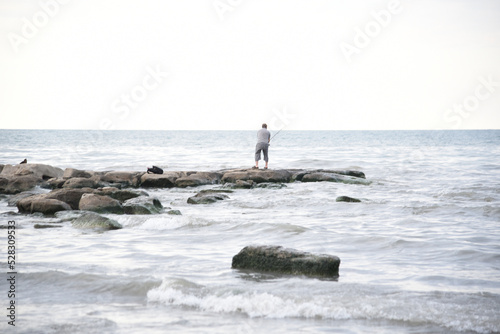 Fisherman with freshly caught fish on a fishing rod by the sea happy on the seashore
