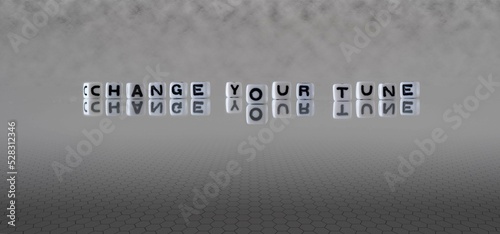 change your tune word or concept represented by black and white letter cubes on a grey horizon background stretching to infinity