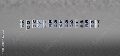 counterargument word or concept represented by black and white letter cubes on a grey horizon background stretching to infinity photo