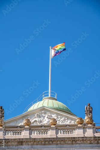 LGBTQ flag flying over the dome of a landmark building in London.