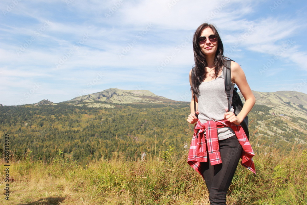 The girl travels through the mountains. Stylish hipster female traveler with a backpack. The girl travels through the mountains. Stylish hipster female traveler with a backpack.
