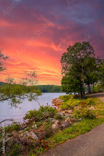 a gorgeous summer landscape at Lake Allatoona with green water surrounded by lush green trees, grass and plants with powerful clouds at sunset at Red Top Mountain State Park in Acworth Georgia USA photo