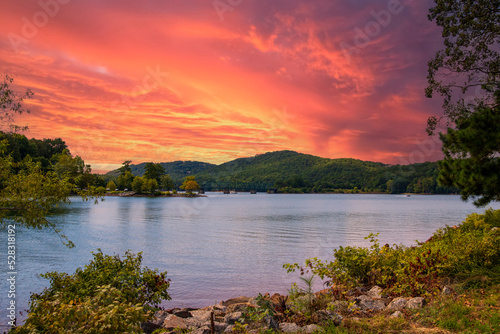 a gorgeous summer landscape at Lake Allatoona with green water surrounded by lush green trees, grass and plants with powerful clouds at sunset at Red Top Mountain State Park in Acworth Georgia USA photo