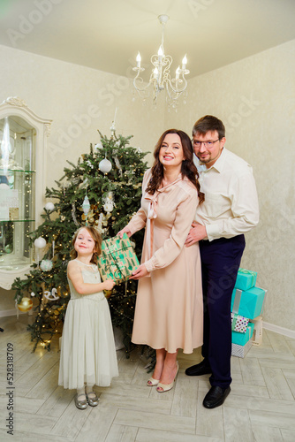 happy family with box of gift by Christmas tree. tradition giving gifts