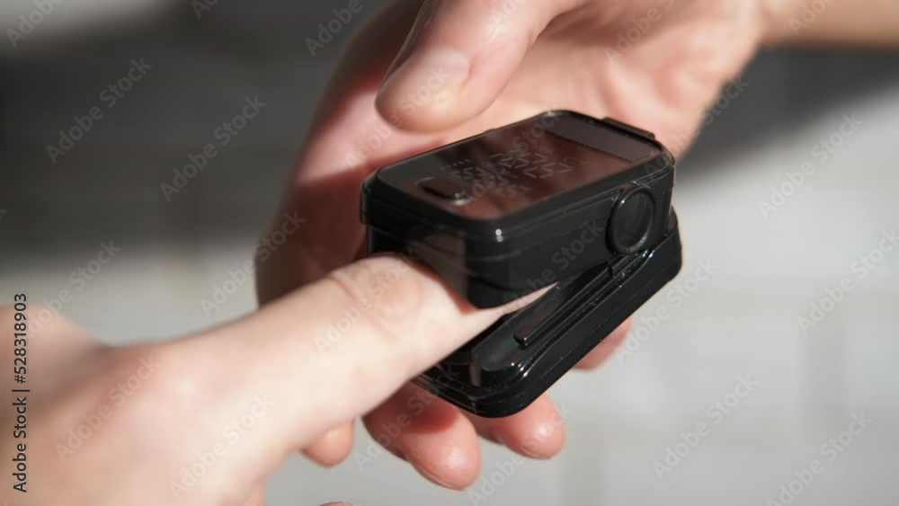 Lady measure oxygen saturation. Somebody measure the oxygen saturation on woman's finger with a pulseoximeter in the room. Lady measure oxygen saturation. Somebody measure the oxygen saturation on woman's finger with a pulseoximeter in the room.