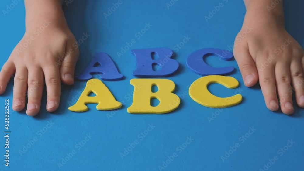 Child's hand playing with letters of the alphabet