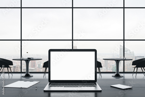 Close up of empty white laptop screen on gray office desktop with supplies on panoramic window and city view background. Mock up  3D Rendering.