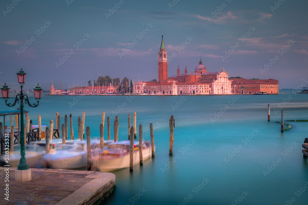 Fototapeta premium Boats docked by wooden mooring poles in grand canal, Ethereal Venice, Italy