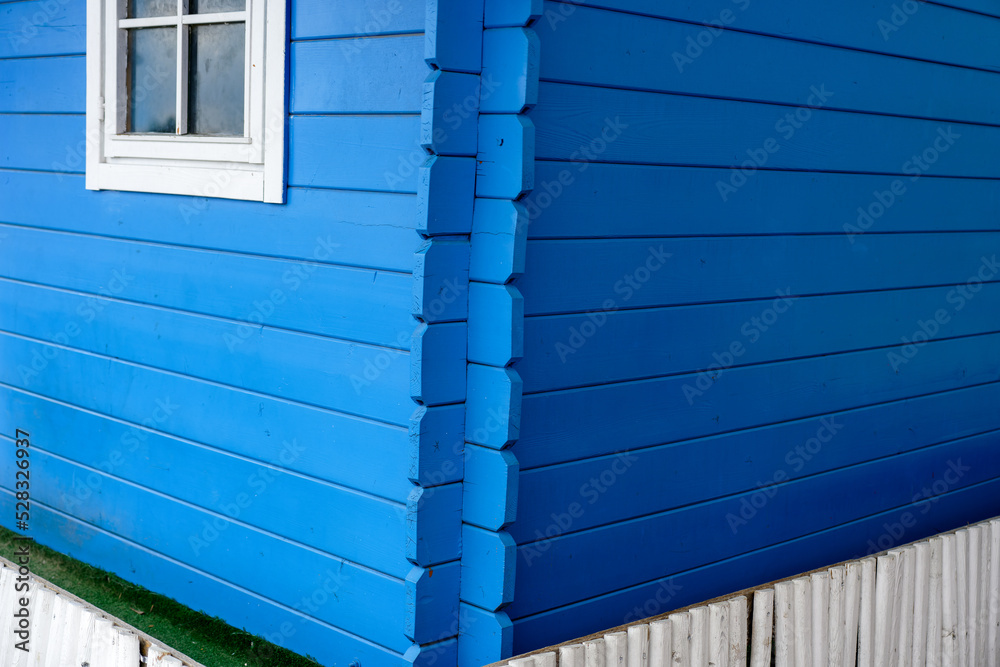 Blue shutter, wooden wall and white windows Blue shutter, wooden wall and white windows