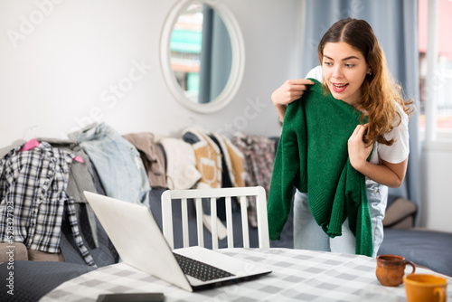 Young woman having online consultation with personal fashion stylist about her wardrobe photo