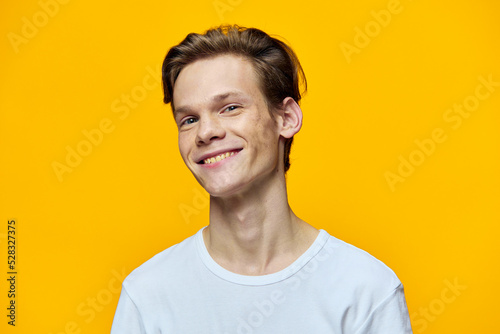 portrait of a cute, smiling guy with straight teeth in a white T-shirt