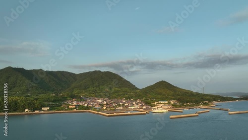 Aerial view of small island fishing town and harbor at base of green mountains photo