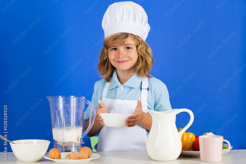Child chef isolated on blue. Funny little kid chef cook wearing uniform cook cap and apron cooked food in the kitchen. Child chef isolated on blue. Funny little kid chef cook wearing uniform cook cap and apron cooked food in the kitchen.