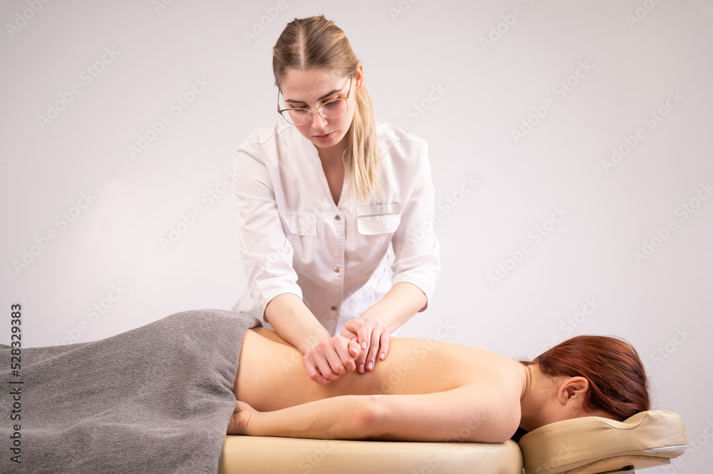 Obraz premium Doctor massaging the back of a female patient. 