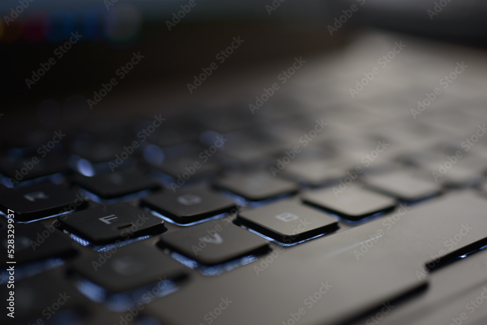 Computer and laptop keyboard details. Black buttons and white color letters on beige and aluminum laptop body