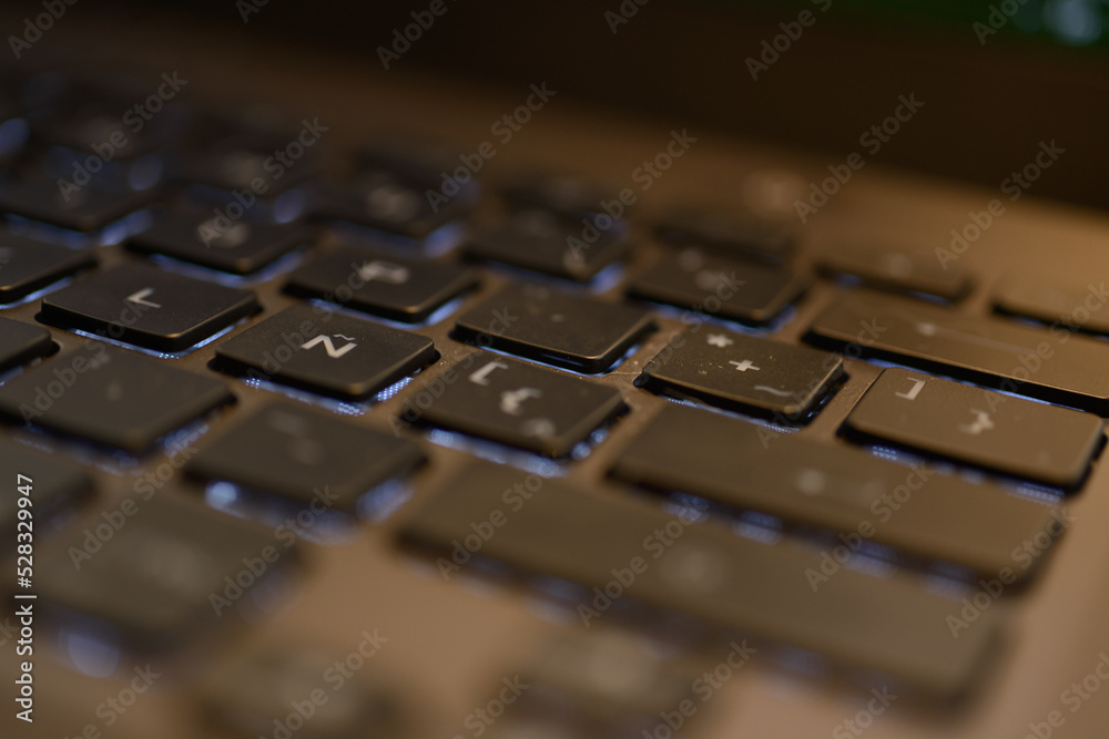Computer and laptop keyboard details. Black buttons and white color letters on beige and aluminum laptop body Computer and laptop keyboard details. Black buttons and white color letters on beige and aluminum laptop body