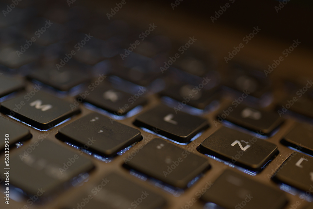 Computer and laptop keyboard details. Black buttons and white color letters on beige and aluminum laptop body Computer and laptop keyboard details. Black buttons and white color letters on beige and aluminum laptop body