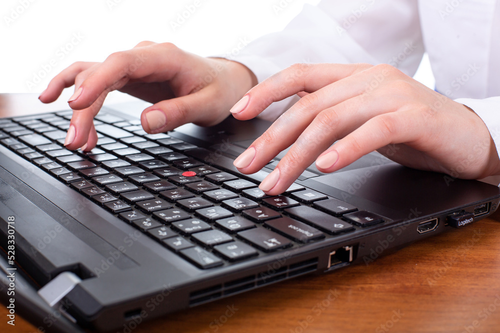 Beautiful young brunette girl typing on a laptop keyboard, office or firm worker, in white shirt isolated on white background Beautiful young brunette girl typing on a laptop keyboard, office or firm worker, in white shirt isolated on white background