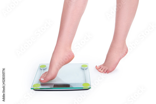 Slim caucasian girl stepping barefoot on wheights isolated on white background