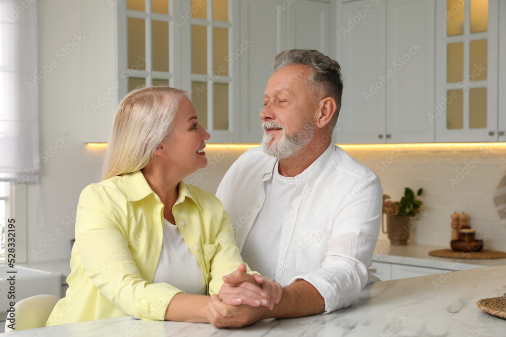 Fototapeta premium Happy senior couple at table in kitchen
