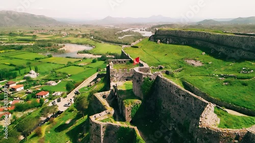 Aerial view flying away from the Albanian flag on castle ruins on a hill photo