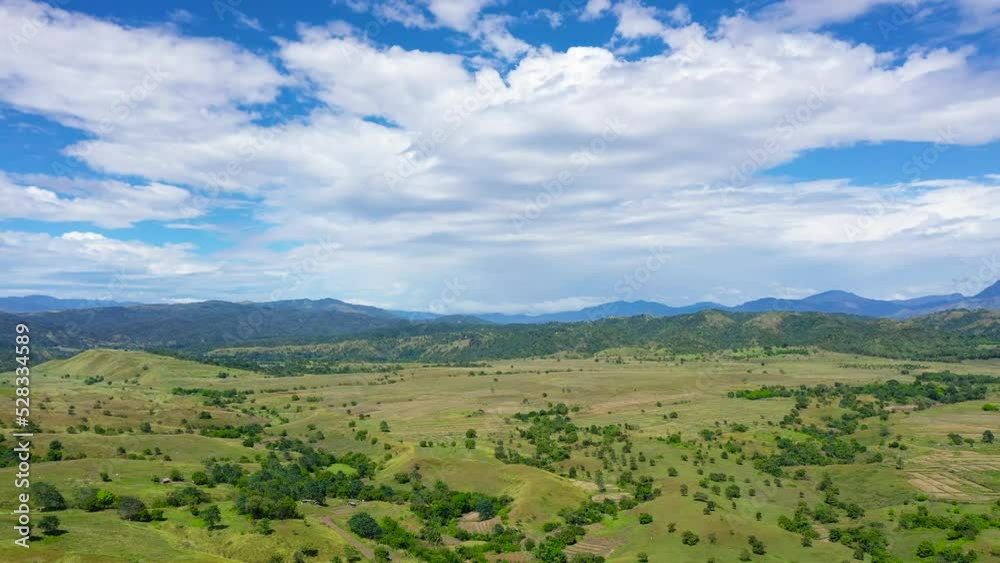 Hills and mountains covered with green grass and rainforest against a background of blue sky and clouds. Philippines, Luzon. Summer landscape. Hills and mountains covered with green grass and rainforest against a background of blue sky and clouds. Philippines, Luzon. Summer landscape.