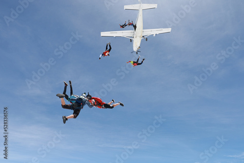 Skydiving. Skydivers are in the sky.