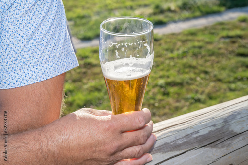 verre de bière dans la main d'un homme en chemise d'été photo