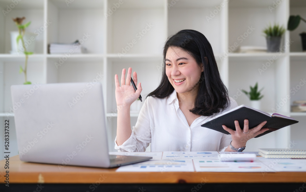Cheerful working woman waving hand, chatting online, making video call on laptop computer.. Cheerful working woman waving hand, chatting online, making video call on laptop computer..