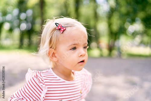 Foto Little girl with a hairpin in red polka dots