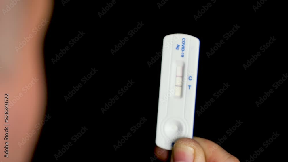 Close up of a man looking at covid-19 test. Concept, black background. Close up of a man looking at covid-19 test. Concept, black background.