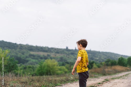 A six-year-old boy runs in the countryside. Happy child boy laughing and playing in the summer day. © Анастасія Стягайло