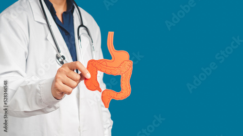 Hand of the doctor holding a colon symbol while standing on a blue background