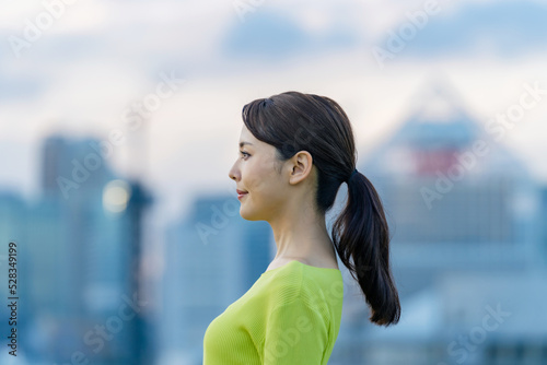 都市の前で遠くを眺める女性