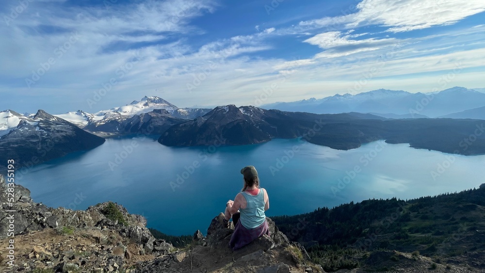 Woman hiker overlooking big glacier fed lake in Canada. 
