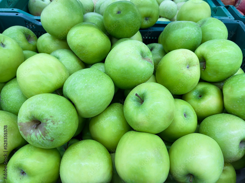 Green apples close-up in a box. The fruit department of the store. Green apples close-up in a box. The fruit department of the store.