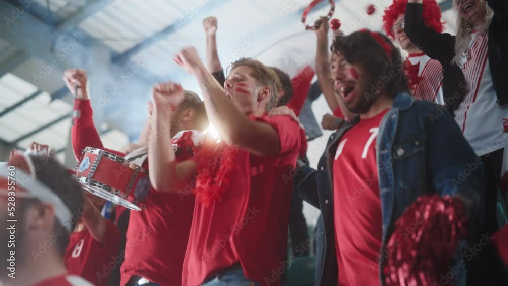 Sport Stadium Event: Crowd of Fans Cheer for their Red Soccer Team to Win. People Celebrate Scoring a Goal, Championship Victory. Group of Friends with Painted Faces Cheer, Shout, Have Emotional Fun