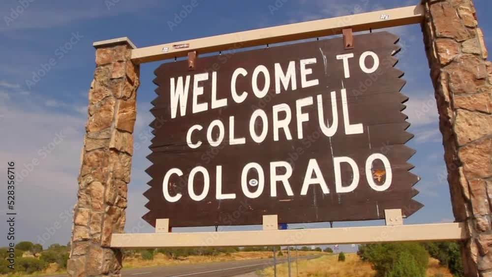 Panning Shot Of Welcome Sign Board By Road On Sunny Day - Telluride, Colorado