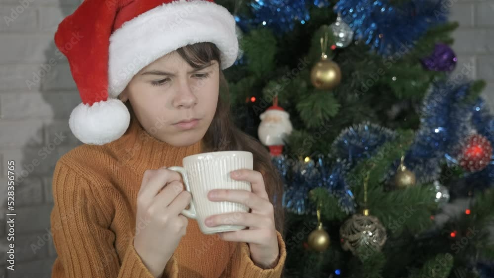 Teen festive Christmas with warm tea. A young girl with bad mood relax in the room with a cup of Christmas beverage. Teen festive Christmas with warm tea. A young girl with bad mood relax in the room with a cup of Christmas beverage.