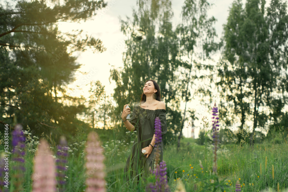 An attractive woman in a field with a summer bouquet of wildflowers Lupinus. Front view. An attractive woman in a field with a summer bouquet of wildflowers Lupinus. Front view.