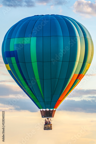 Colorful air balloon in the cloudy sunset sky