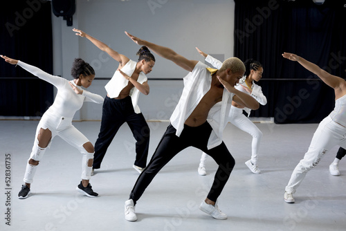 Group of modern dancers practicing a dance routine in a studio photo