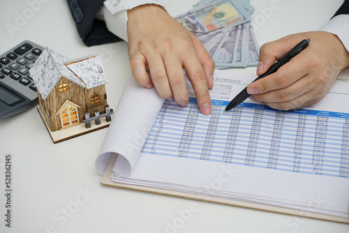 Real estate agent showing loan amortization schedule to client. Real estate, home loan and investments concept.