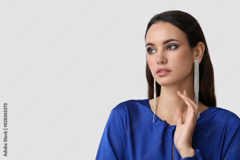 Beautiful young woman with stylish jewelry on light background Beautiful young woman with stylish jewelry on light background