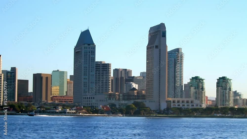 Lockdown Shot Of Speedboat Moving On Water By Downtown District Against Clear Sky - San Diego, California Lockdown Shot Of Speedboat Moving On Water By Downtown District Against Clear Sky - San Diego, California