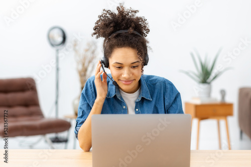 Obraz na płótnie Beautiful woman call center worker in headphones is working at modern office
